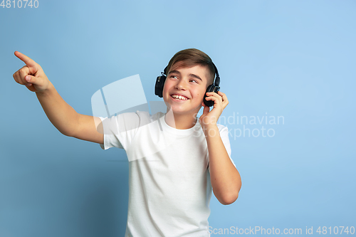 Image of Caucasian teen\'s portrait isolated on blue studio background