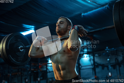 Image of Caucasian man practicing in weightlifting in gym