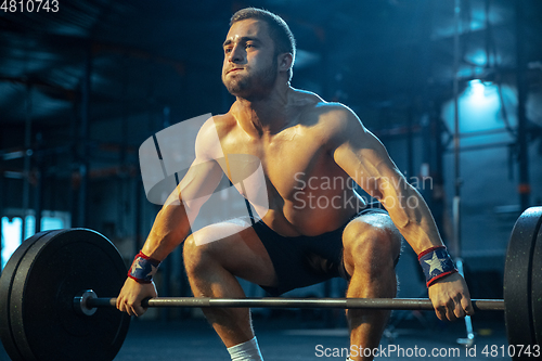 Image of Caucasian man practicing in weightlifting in gym