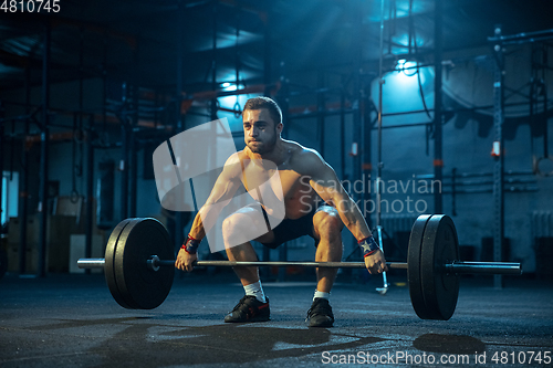 Image of Caucasian man practicing in weightlifting in gym