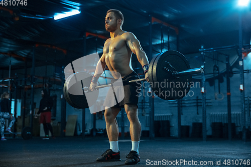 Image of Caucasian man practicing in weightlifting in gym