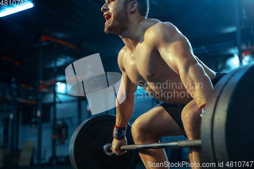 Image of Caucasian man practicing in weightlifting in gym