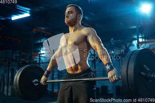 Image of Caucasian man practicing in weightlifting in gym