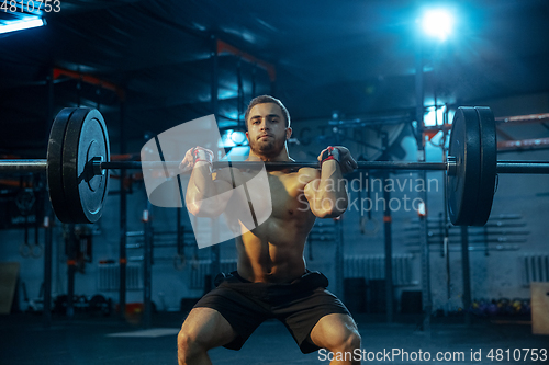 Image of Caucasian man practicing in weightlifting in gym