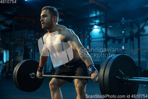 Image of Caucasian man practicing in weightlifting in gym