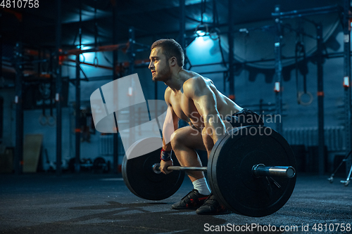 Image of Caucasian man practicing in weightlifting in gym