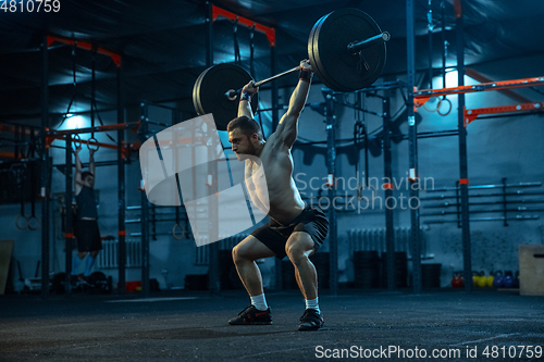 Image of Caucasian man practicing in weightlifting in gym