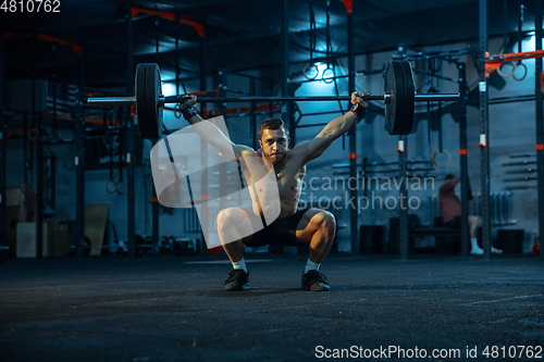 Image of Caucasian man practicing in weightlifting in gym