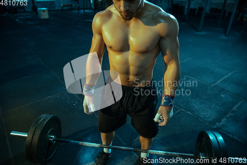 Image of Caucasian man practicing in weightlifting in gym