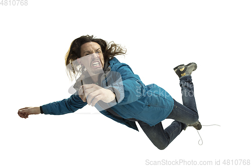 Image of A second before falling - young man falling down with bright emotions and expression