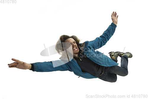 Image of A second before falling - young man falling down with bright emotions and expression