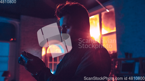 Image of Cinematic portrait of handsome man in neon lighted interior