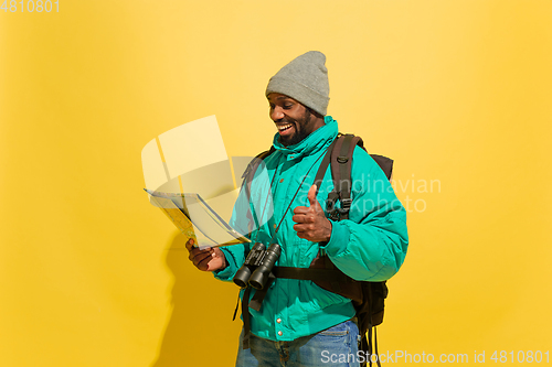 Image of Full length portrait of a cheerful young african tourist guy isolated on yellow background