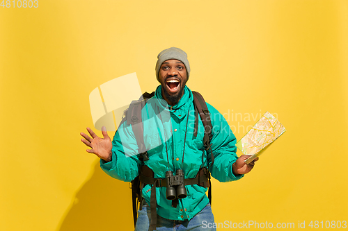 Image of Full length portrait of a cheerful young african tourist guy isolated on yellow background