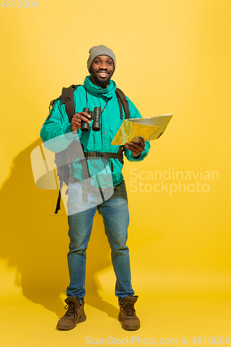 Image of Full length portrait of a cheerful young african tourist guy isolated on yellow background