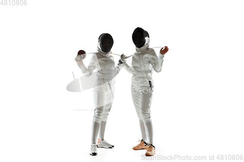 Image of Teen girls in fencing costumes with swords in hands isolated on white background