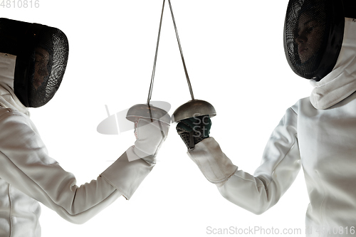 Image of Teen girls in fencing costumes with swords in hands isolated on white background