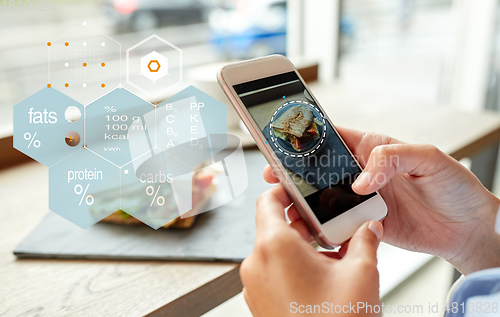 Image of hands with phone and food nutritional value chart