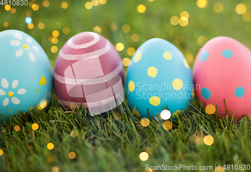 Image of row of colored easter eggs on artificial grass