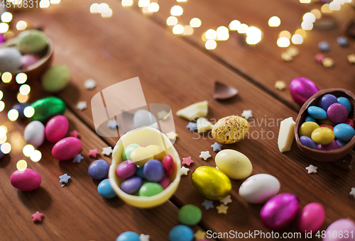 Image of chocolate eggs and candy drops on wooden table