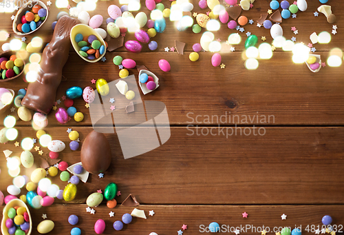 Image of chocolate eggs, easter bunny and candies on wood