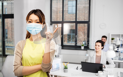 Image of asian woman in protective medical mask at office