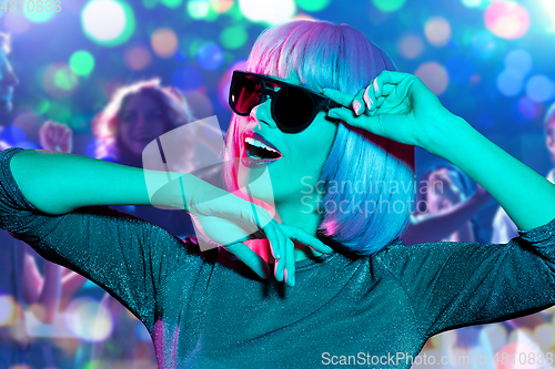 Image of woman in wig and sunglasses dancing at nightclub