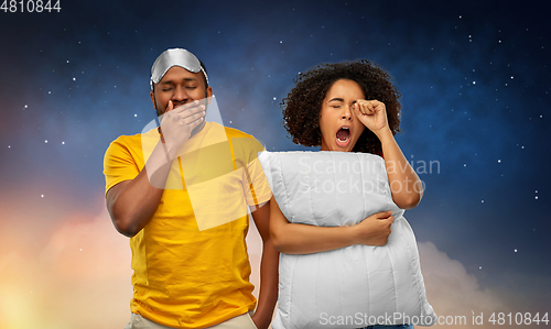 Image of african couple with eye sleeping mask and pillow