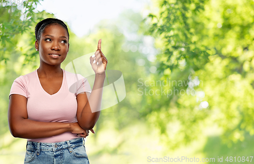 Image of happy african american woman pointing finger up