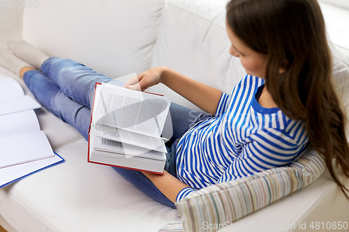 Image of close up of teenage girl reading book at home