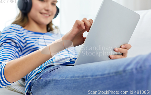 Image of teenage girl listening to music on tablet computer