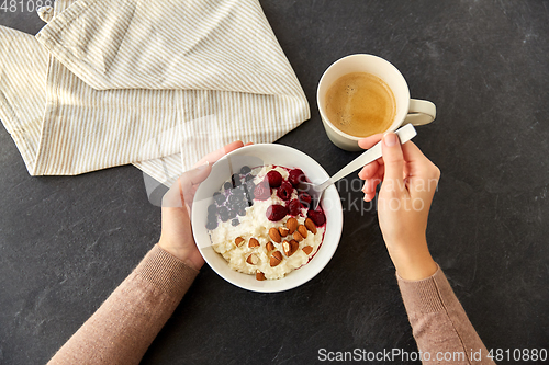 Image of hands with porridge breakfast and cup of coffee