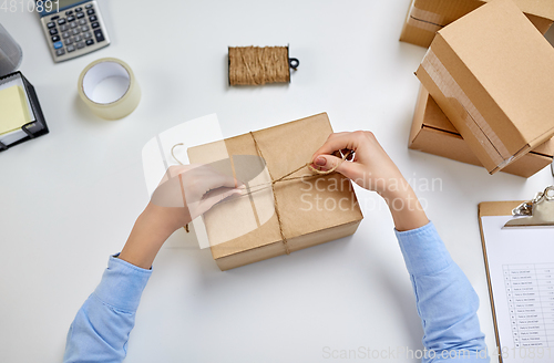 Image of female hands packing parcel box at post office