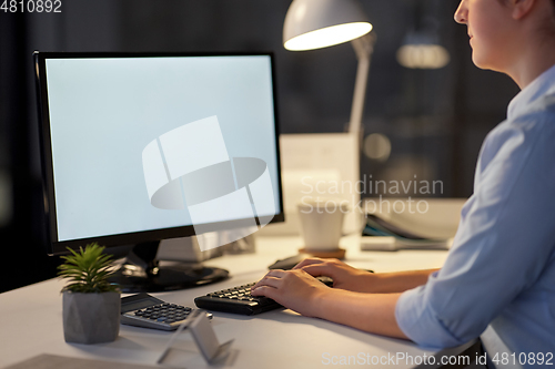 Image of businesswoman working on computer at night office