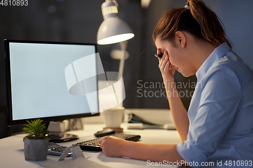 Image of stressed businesswoman with computer at night