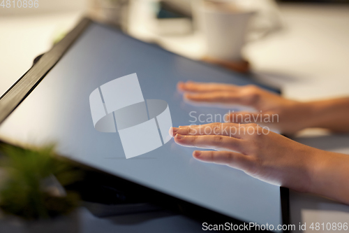 Image of hands on led light tablet at night office