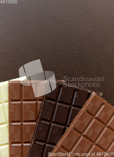 Image of different kinds of chocolate on brown background