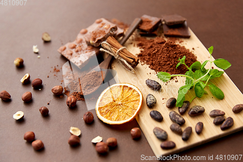 Image of chocolate with hazelnuts, cocoa beans and powder