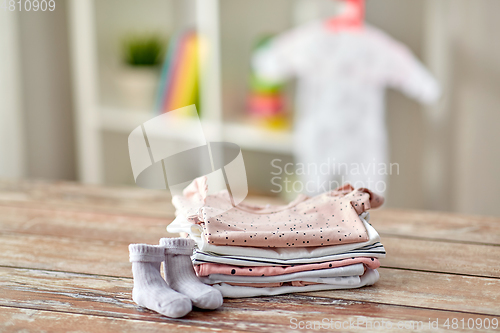 Image of baby clothes on wooden table at home