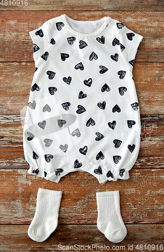 Image of baby bodysuit and socks on wooden table