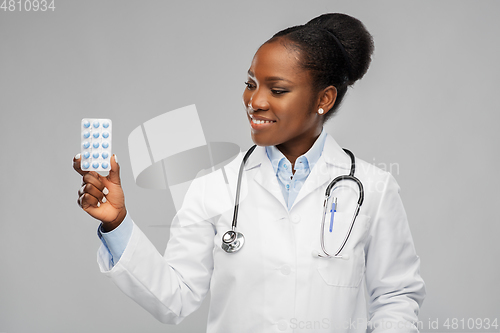 Image of african american female doctor with medicine pills