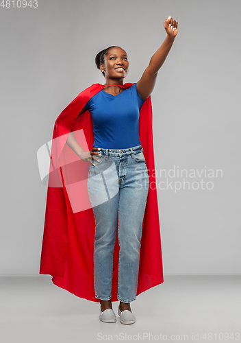 Image of happy african american woman in red superhero cape