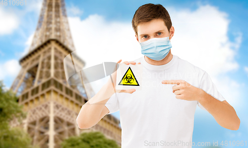 Image of man in mask with biohazard sign in france