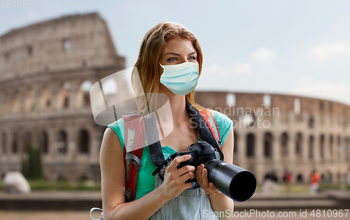 Image of happy woman with backpack and camera outdoors