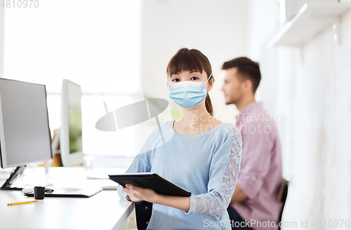 Image of asian woman in protective medical mask at office