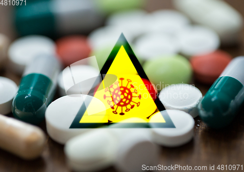 Image of coronavirus caution sign and drugs in pills