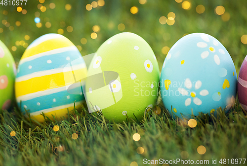 Image of row of colored easter eggs on artificial grass