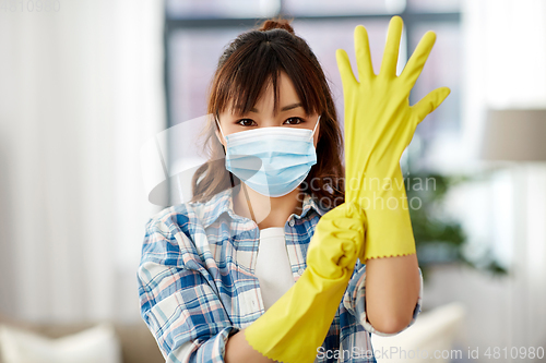 Image of asian woman in protective mask and rubber gloves