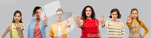 Image of group of different women making stopping gesture