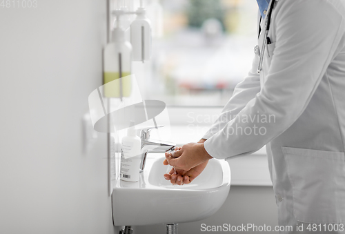 Image of doctor washing hands at hospital sink